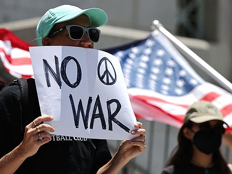 Demonstrators gather outside City Hall during a rally opposing the United States' strikes on Iran.