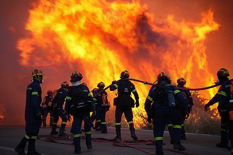 Firefighters battle a large wildfire burning in Karyes village, on the eastern Aegean island of Chios, Greece, Sunday, June 22, 2025.