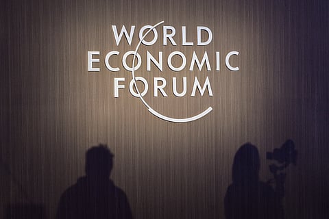 Shadows of journalists are seen beside WEF signage during a session at the World Economic Forum Annual Meeting of the New Champions 2025 (AMNC25) in Tianjin on June 24, 2025.