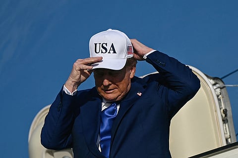 US President Donald Trump adjusts his cap as he exits Air Force One, which landed from Joint Base Andrews, Maryland, at Amsterdam's Schiphol aiport, to attend the NATO summit in The Hague, on June 24, 2025.