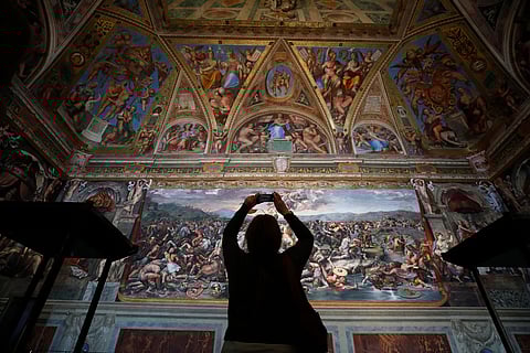 A visitor admires a Raphael Room inside the Vatican Museums at the Vatican, on May 3, 2021.