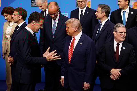 President Donald Trump, center, speaks with NATO Secretary General Mark Rutte, left, during a group photo of NATO heads of state and government at the NATO summit in The Hague, Netherlands, Wednesday, June 25, 2025.