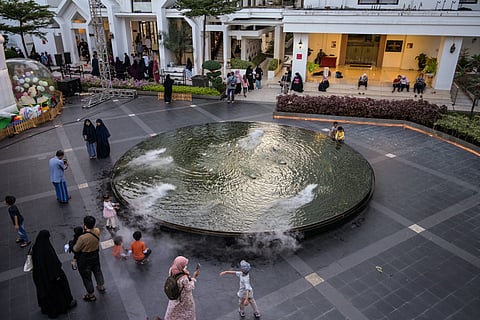 People gather beside a fountain in Surabaya on June 28, 2025.