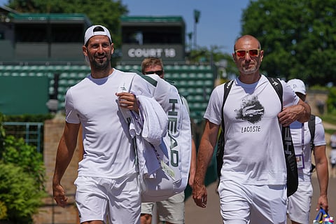 Novak Djokovic of Serbia, left, attends a practice session ahead of the Wimbledon tennis Championships in London, Friday, June 27, 2025.