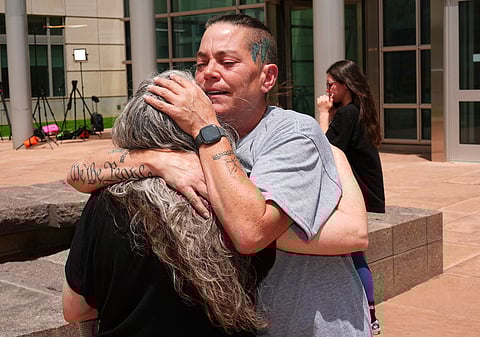 Crystina Page, right, hugs Beth Mosley, who both had retained the services of a Colorado funeral home owner who stashed nearly 190 decomposing bodies.