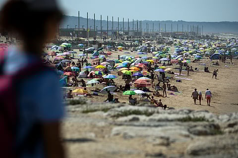 This picture shows people on Costa da Caparica beach in Almada, near Lisbon, during the first heatwave of the year, on June 29, 2025.
