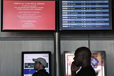 Passengers look at the departures information board at Roissy Charles-de-Gaulle airport, outside Paris
