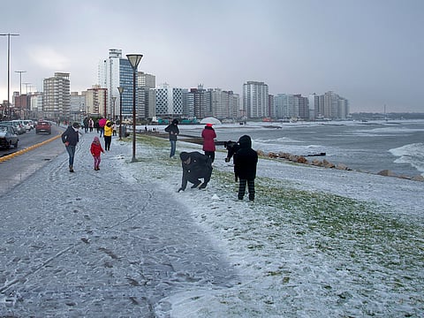 People play with snow on a beach in Miramar, Buenos Aires Province, Argentina, on June 30, 2025.