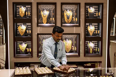 A salesman arranges gold chains at a jewellery store on July 5, 2025.