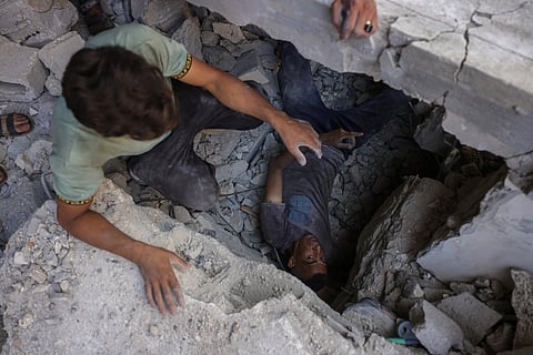 Palestinians search for survivors in the rubble of a building in the Sheikh Radwan neighbourhood in Gaza City, in the central Gaza Strip that was targeted in an Israeli strike on July 6, 2025.