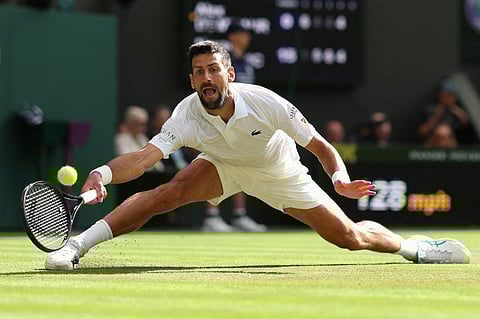 Serbia's Novak Djokovic plays a forehand return to Australia's Alex De Minaur during their men's singles fourth round tennis match on the eighth day of the 2025 Wimbledon Championships at The All England Lawn Tennis and Croquet Club in Wimbledon, southwest London, on July 7, 2025.