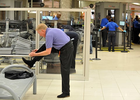 A traveller removes his shoes at Hartsfield-Jackson Atlanta International Airport on Wednesday, Jan. 15, 2014 in Atlanta.