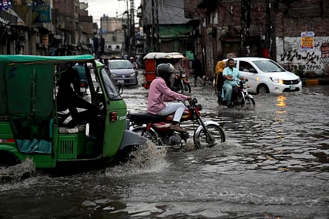 Motorists drive through a flooded road caused by heavy monsoon rains, in Lahore, Pakistan, Sunday, June 29, 2025.