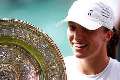 Poland's Iga Swiatek celebrates with the winner's trophy, the Venus Rosewater Dish, after winning women's singles final of the 2025 Wimbledon Championships in London on July 12, 2025.