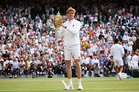 Italy's Jannik Sinner celebrates with the winner's trophy as he poses for pictures following his victory against Spain's Carlos Alcaraz at the end of their men's singles final tennis match on the fourteenth day of the 2025 Wimbledon Championships at The All England Lawn Tennis and Croquet Club in Wimbledon, southwest London, on July 13, 2025.