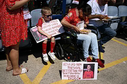 Fans hold signs in memory of Liverpool's late Portuguese striker #20 Diogo Jota before the pre-season friendly football match between Preston North End and Liverpool at Deepdale stadium in Preston, north-west England on July 13, 2025.