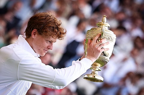 Italy's Jannik Sinner celebrates with the winner's trophy following his victory in the men's singles final of the 2025 Wimbledon Championships in London, on July 13, 2025.