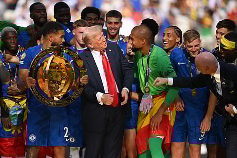 Reece James of Chelsea FC holds the Fifa Club World Cup trophy after their team's victory as American President Donald Trump interacts with Robert Sanchez during the presentation ceremony on Sunday.