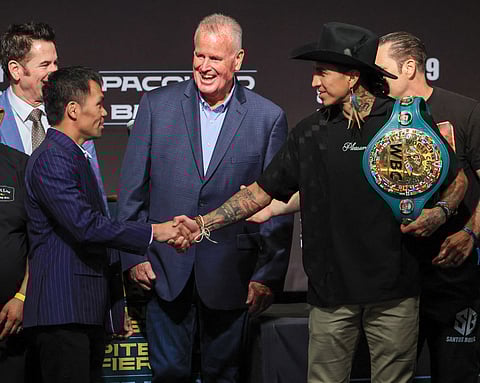 TGB Promotions President Tom Brown (C) looks on as Manny Pacquiao (L) and WBC welterweight champion Mario Barrios (R) shake hands after facing off during their news conference at MGM Grand Hotel & Casino on July 16, 2025 in Las Vegas, Nevada.