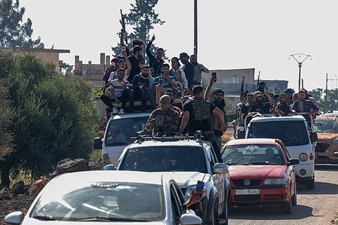Tribal and bedouin fighters cross the al-Dur village in Syria's southern Sweida governorate as they mobilise amid clashes with Druze gunmen on July 18, 2025.