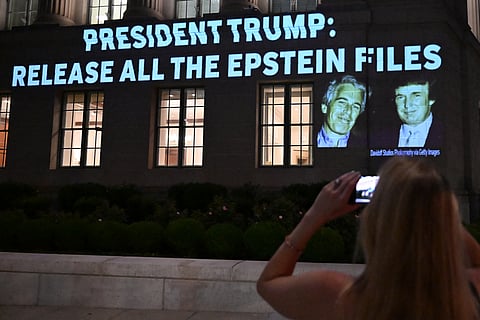 A person takes a photo as a message calling on President Donald Trump to release all files related to Jeffrey Epstein is projected onto the US Chamber of Commerce building across from the White House in Washington, DC, on July 18, 2025.