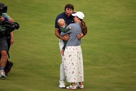 US golfer Scottie Scheffler celebrates with his wife Meredith and son Bennett on the 18th green after his victory in the 153rd Open Championship at Royal Portrush golf club in Northern Ireland on July 20, 2025.