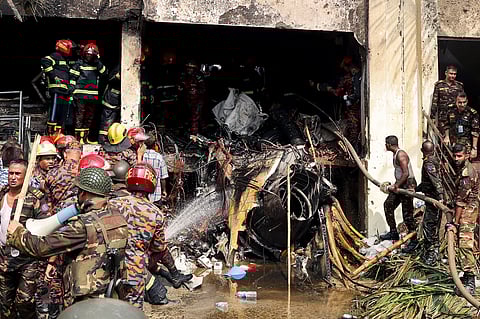 Bangladesh's fire service and security personnel conduct a search and rescue operation after an Air Force training jet crashed into school in Dhaka on July 21, 2025.