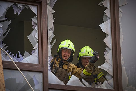 Firefighters work in a destroyed apartment building after a Russian attack in Kyiv, Ukraine, Monday, July 21, 2025.
