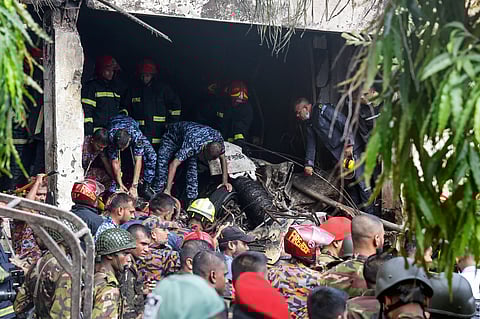 Bangladesh's fire service and security personnel conduct a search and rescue operation after a Air Force training jet crashed into school in Dhaka on July 21.