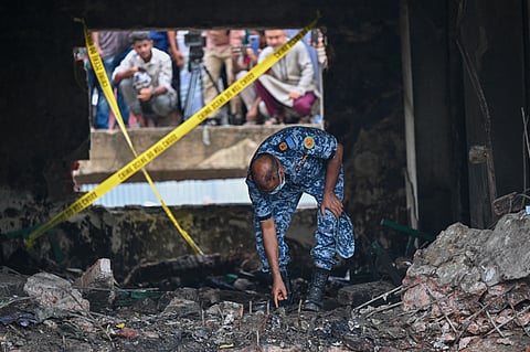 A Bangladesh Air Force personnel inspects the crash site a day after a training jet crashed into a school in Dhaka on July 22, 2025.