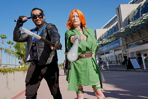 Ivan Martinez, left, dressed as "Nightwing," and Jade Stone, dressed as "Poison Ivy Jedi," pose for a photo before the 2025 Comic-Con International Preview Night on Wednesday, July 23, 2025, in San Diego. (AP Photo/Chris Pizzello)
