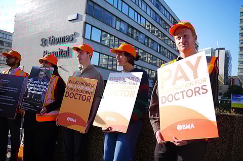 NHS resident doctors hold placards outside St Thomas' Hospital in London, as resident doctors in England, formerly referred to as junior doctors, begin a five-day strike after talks with the government collapsed over pay, Friday, July 25, 2025.