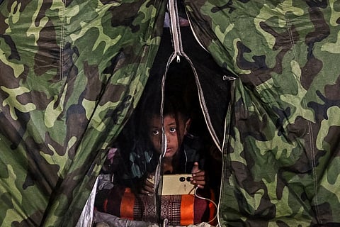 A boy displaced by the ongoing conflict between Thailand and Cambodia rests at an evacuation center in the Thai border province of Si Sa Ket on July 26, 2025.