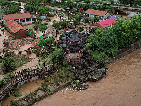 An aerial view shows damaged buildings after heavy rains at Xin'anzhuang village, in Miyun district, on the outskirts of Beijing on July 28, 2025.