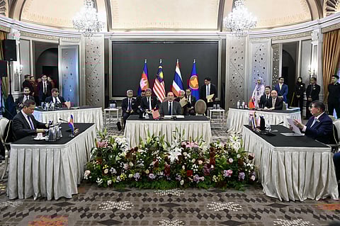 Malaysia's Prime Minister Anwar Ibrahim (C) looks on as Cambodia's Prime Minister Hun Manet (L) and Thailand's acting Prime Minister Phumtham Wechayachai (R) take part in talks on a possible ceasefire between Thailand and Cambodia in Putrajaya on July 28, 2025.