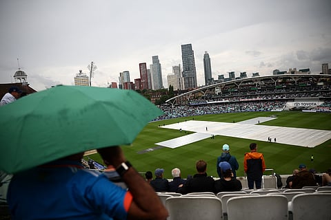 Spectators look on as rain stops play on the first day of the fifth Test cricket match between England and India at The Oval in London on Thursday.