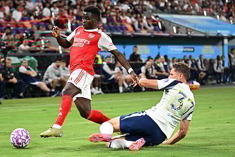 Arsenal’s Bukayo Saka (L) and Tottenham Hotspur's Micky van de Ven fight for the ball during their friendly exhibition football match at the Kai Tak Stadium in Hong Kong on July 31, 2025.