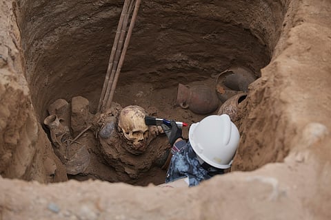 Archaeologist Jose Aliaga works at the site where city workers discovered ancient remains.