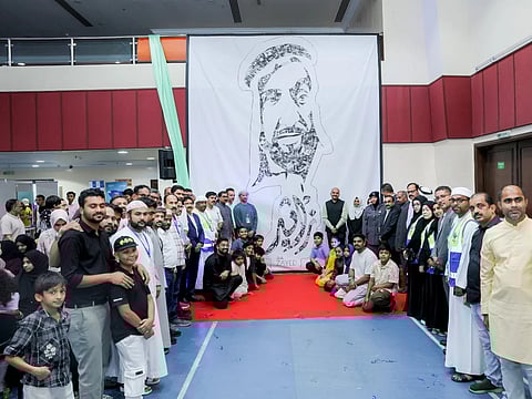Students who created the collage pose for a photo with community members at the unveiling ceremony recently held in Abu Dhabi.