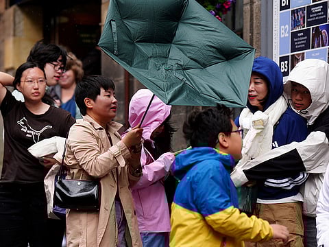 Members of the public battle against the wind as they walk along the Royal Mile, in Edinburgh, Scotland, Monday Aug. 4, 2025.