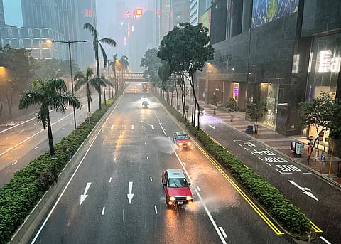 Taxis and other vehicles drive along a waterlogged Gloucester Road in Hong Kong's Wanchai district on August 5, 2025, amid a black rainstorm warning issued by the city's weather observatory.