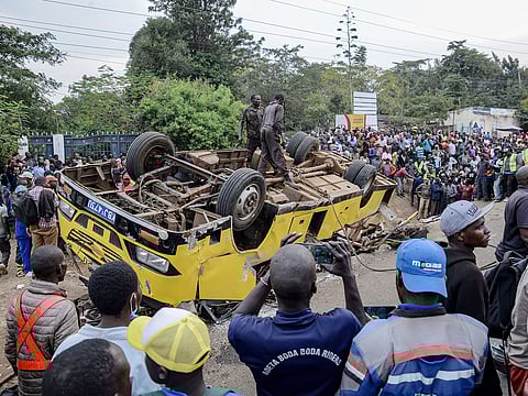 People gather at the scene of a bus accident that overturned, killing several people, in Kisumu, Kenya, on Friday, August 8, 2025.