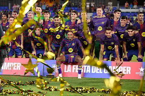 Barcelona players pose with their trophy after winning the 60th Joan Gamper Trophy football match between FC Barcelona and Como 1907 at Johan Cruyff Stadium in Barcelona on August 10, 2025.