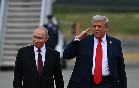 US President Donald Trump salutes as he walks with Russian President Vladimir Putin.