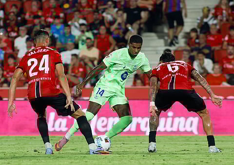 Real Mallorca's defender Martin Valjent, midfielder Antonio Sanchez battle for the ball with Barcelona's forward Marcus Rashford during the Spanish league football match at Mallorca Son Moix Stadium in Palma de Mallorca on August 16, 2025.