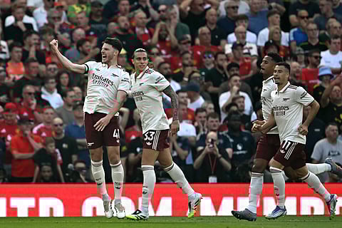 Arsenal's midfielder Declan Rice (L) and defender Riccardo Calafiori (2L) celebrate scoring the opening goalduring the English Premier League football match against Manchester United at Old Trafford in Manchester, north west England, on August 17, 2025.