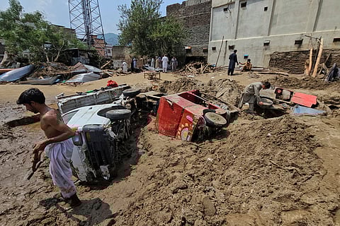 Local residents remove mud to recover vehicles from debris after Friday's flash flooding, in Mingora, the main town of Swat Valley, in Pakistan's northwest on August 16, 2025.