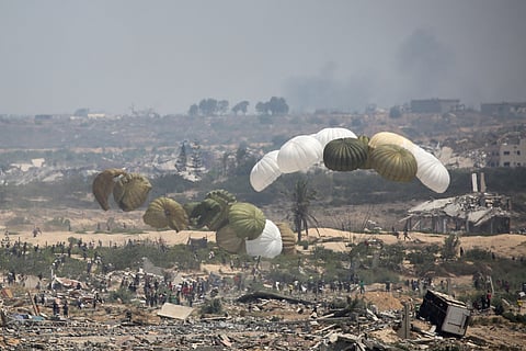 Aid pallets are parachuted after being dropped from a military plane over Nuseirat in the central Gaza Strip during an airdrop mission above the Israel-besieged Palestinian territory on August 18, 2025.