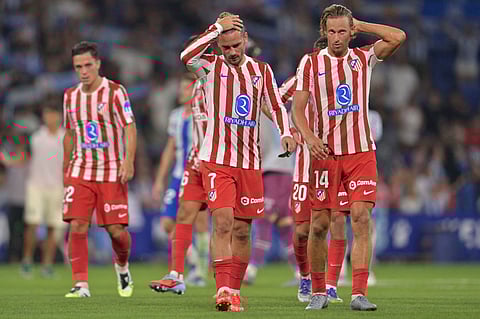 Atletico Madrid's midfielder Marcos Llorente and forward Antoine Griezmann react at the end of the Spanish league football match against RCD Espanyol at RCDE Stadium in Cornella de Llobregat on August 17, 2025.