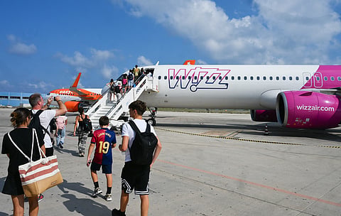 Passengers embark aboard a Wizz air jet at the Lampedusa airport. Wizz Air has announced plans to bring back flights to Dubai, Abu Dhabi, Jeddah and Amman, with 12 routes and 49 weekly flights.
